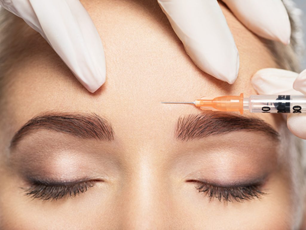 Woman getting cosmetic injection of botox near eyes in Spring Texas by SavvyChicMedSpa